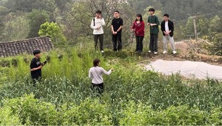 实践团观看主播爱莲拍摄视频并交流。贵州大学管理学院供图