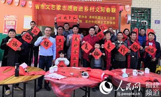 省市文艺家志愿者进乡村义写春联。