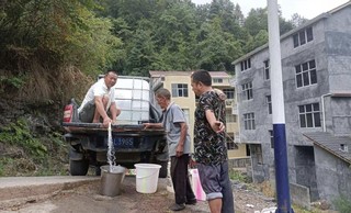 湖北中烟恩施卷烟厂驻龙潭河村工作队送水入户抗旱情。