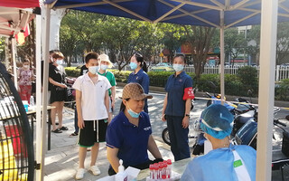 鸿琰实业职工协助社区维持核算检测现场秩序。