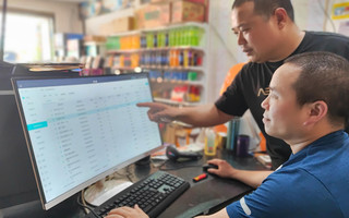 工作人员指导工业园大街客户使用现代化的店铺管理系统。