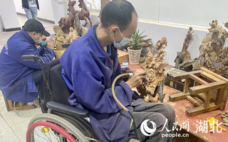 学员在神农架残创中心进行木雕制作。人民网 张沛摄