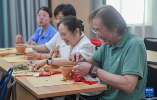 7月5日，在湖北省武汉市叶开泰中医药文化园，“海峡两岸媒体荆楚行”参访团成员体验制作香包。新华社记者 杜子璇 摄