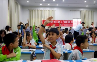 兴隆小学的学生举手参加阅读推广互动环节。