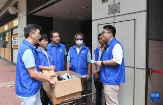  3月27日，荃湾区杨屋道关爱队队长、区议员伍俊瑜（右一）给关爱队义工布置任务。新华社记者 陈铎 摄