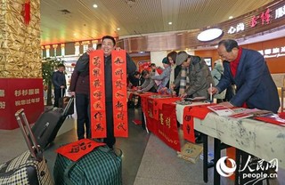 “这春联写得真好看！我回家一定贴在大门上！”来自安徽寿县的旅客激动地展示着自己刚收到的春联。据悉，上海火车站组织了沪上的书法家们现场为旅客书写春联，赠送福字。