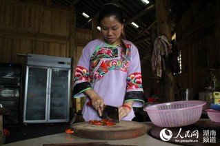 施成富老人的儿媳妇正在为来农家乐的游客准备饭菜