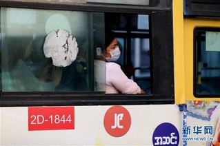 3月13日,在缅甸仰光,一名女子佩戴口罩乘坐公交车出行.