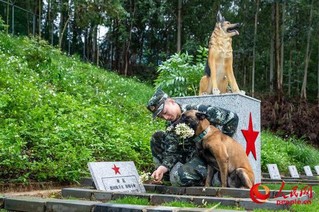 驯导员孔德鑫和军犬“凯特”向逝去的军犬献花。
