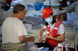 志愿者给受灾群众发放药品。苗子健摄