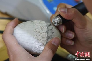 图为使用机器辅助雕刻，选用质地较厚的蛋壳作为材料，以浅浮雕或镂空的手法进行操作。　刘玉桃 摄