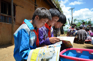 2016年10月，悦乐镇新寨村海坝小组的孩子们阅读“背篼图书馆”送去的儿童书籍。 受访者供图