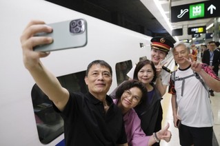   6月15日，乘坐香港西九龙至北京西D910次高铁动卧列车的旅客在香港西九龙站站台上拍照留念。新华社记者 王申 摄