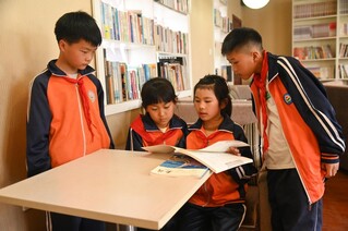 4月22日，贵州省铜仁市松桃苗族自治县盘信镇民族完小的学生们在一起阅读书籍。 谢慧芳摄.JPG