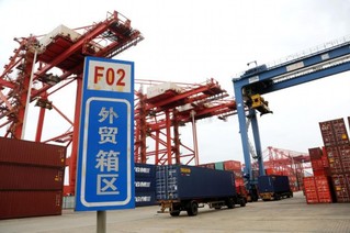 5月9日，在江苏省连云港港集装箱码头，运输车辆向货轮转运集装箱。新华社发（王春摄）