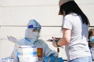 5月16日，在北京市朝阳区建外街道北郎社区一处核酸检测点，志愿者引导居民排队进行核酸检测。新华社记者 鞠焕宗 摄
