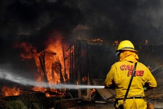 12月5日，在美国加利福尼亚州南部文图拉县，消防员为着火建筑灭火。新华社/法新