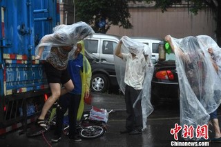 图为重庆突降暴雨民众穿着自制雨衣。　陈超 摄