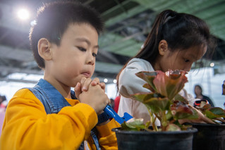 10月5日，在重庆市大足区雍溪镇慈云村的天华百卉园内，小朋友在学习种植技巧。新华社记者唐奕摄