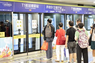 旅客乘坐有轨电车前往S1卫星厅。尚震摄