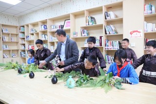 六合村农家书屋图书管理员潘春仁正在教授学生利用本地植物插花，装扮书屋。中共施秉县委宣传部供图