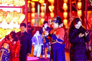 游客在灯会庙市拍照打卡。
