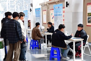 企业代表耐心地与前来投递简历的学生进行交流。