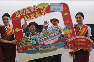   6月15日，乘坐香港西九龙至北京西D910次高铁动卧列车的旅客在香港西九龙站站台上拍照留念。新华社记者 王申 摄