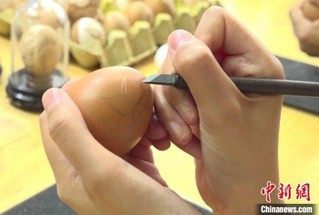 图为学生们用刻刀在蛋壳上雕刻图案。　刘玉桃 摄