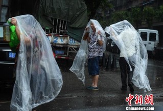 重庆主城突降暴雨街头民众自制雨衣避雨