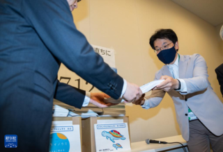 4月24日，在日本东京众议院第二议员会馆，非营利组织“原子能资料情报室”事务局长松久保肇（右）递交签名材料。新华社记者 张笑宇 摄