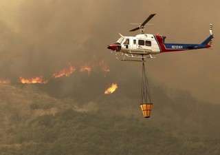 12月5日，在美国加利福尼亚州南部文图拉县，一架直升机参与灭火。新华社/美联