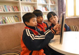 4月22日，贵州省铜仁市松桃苗族自治县盘信镇民族完小的学生们在一起阅读书籍。谢慧芳摄.JPG