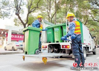 　　杨雄和搭档郑树国相互搭手，将已经装满的餐厨垃圾桶转运到车上。长沙晚报全媒体记者 唐朝昭 摄