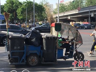 资料图：北京朝阳区劲松街道附近的垃圾车。汤琪 摄