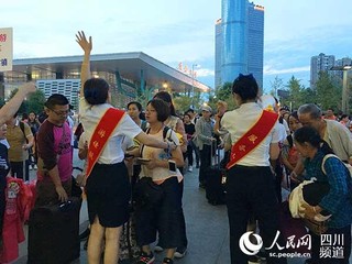 成都东站游佳服务岗工作人员正在为灾区旅客引导服务。