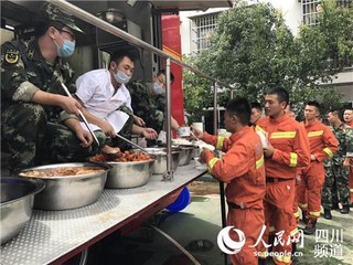 消防官兵在灾区排队打饭。