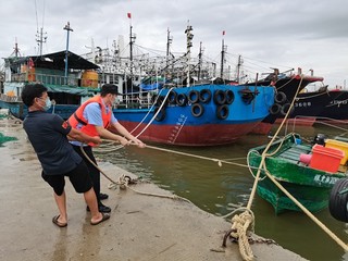 清澜海岸派出所民警在帮助渔民拴紧缆绳。海南省海岸警察总队供图