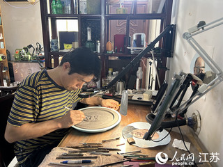 袁中平在砖雕上刻人物肖像。人民网 王丹丹摄
