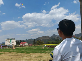 游客们带着孩子放风筝。