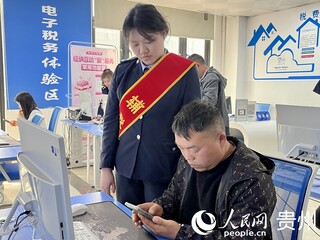 龙里县税务局工作人员手把手帮助新办企业快速了解税收政策、掌握办税流程。人民网 陈洁泉摄