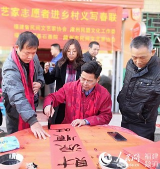 乡亲们为文艺家按纸、倒墨、换水。