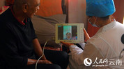 一名村医在患者家里与专家进行交流。杨建顺摄.jpg