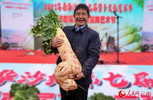 罗勇士抱着13.9公斤的“萝卜王”。人民网记者 刘怡摄