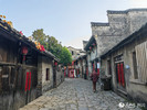 西河古镇建筑古色古香，青石路面蜿蜒曲折，游客漫步在古镇的街道上。