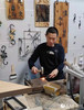 西河古镇铁画工作室内，西河铁画匠人陶绍军在制作铁画。陶绍军制作铁画已有22年的时间，从他手中制作出去的成品有很多件，小到梅兰竹菊四条屏、各种赛事的吉祥物，大到挂满一面墙的大件。