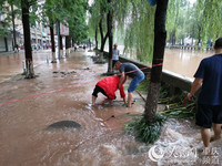 昌元街道党员邓顺才搀扶在洪水中摔倒的群众。荣昌区委组织部供图
