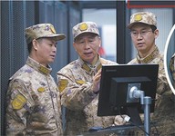 上图：王西安（左二）与队领导筹划保障方案。朱 嘉摄