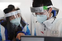 北京冬奧會主媒體中心，志愿者在面罩上標注了自己的名字和笑臉表情。（資料圖）