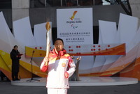 3月2日，第一棒火炬手朱鵬凱在城市火種火炬傳遞中。新華社記者 陶希夷 攝